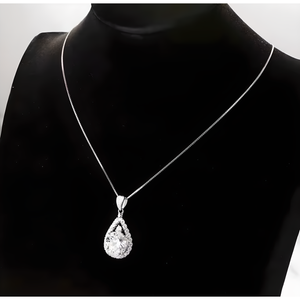 Teardrop-shaped pendant on a necklace against a black background